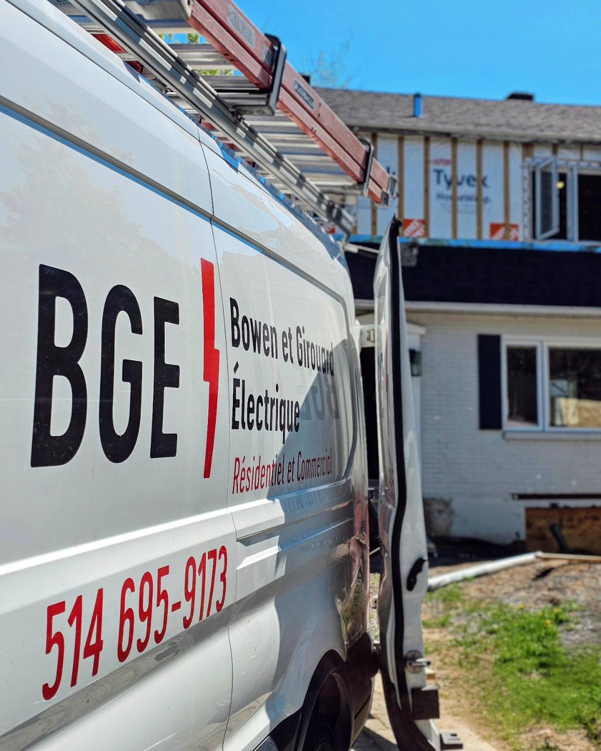 White BGE Electrique van with logo and phone number, next to a house undergoing renovation.